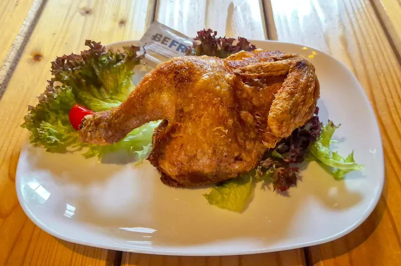 Knuspriges halbes Hähnchen auf Salatblättern angerichtet
