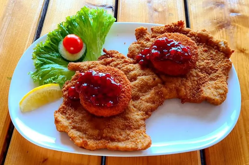 Zwei Schnitzel mit gebackenem Camembert und Preiselbeeren