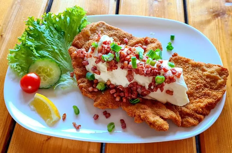 Schnitzel mit Sauerrahm, gebratenen Speckwürfeln und Lauchzwiebeln