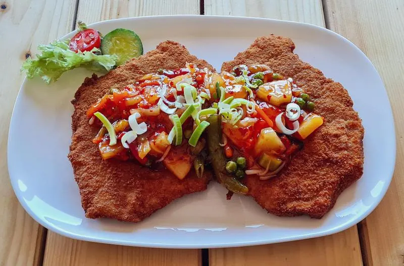 Ganzes Schnitzel mit Wok-Gemüse, Ananas und pikanter Süßsauer-Soße